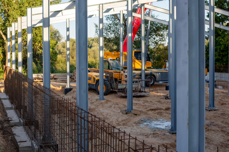 Telescopic handlers and a mobile crane at a construction site inside a building under construction...