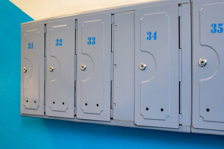 Old apartments steel letter boxes close up. City flats entrance hall mailboxes with apartment...