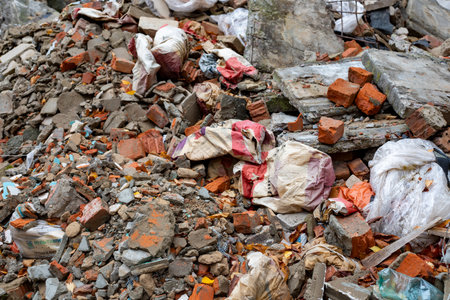 Shattered, broken construction waste as pieces of cinder block concrete rubble and bricks, after building demolition.の写真素材
