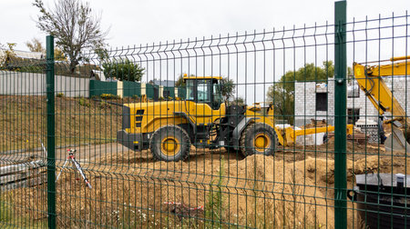 Orange construction equipment at a construction site on a cloudy day. Construction equipment moves...