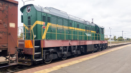 Powerful diesel locomotive pulls a heavy freight car. Freight train on the tracks, seen from behind.の写真素材