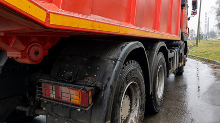 Close-up of the rear wheel of a red cargo truck. Headlights and wheels of the car. The concept of cargo transportation.の写真素材