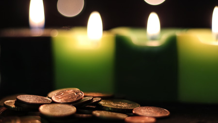Coins lighted with candle lightsの写真素材