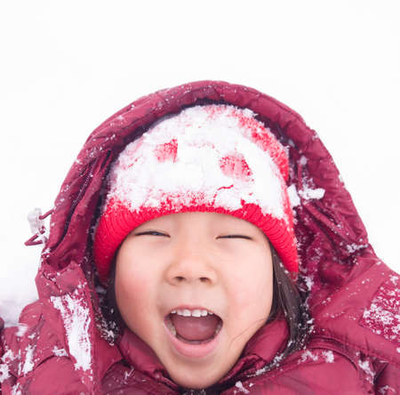 A child in red is played in the yard. Winter children's entertainment.の写真素材