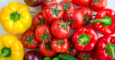 Assorted vegetables on a white background. Bell peppers, tomatoes, cucumbers, red onions on a wooden table. A group of useful natural, organic vitamins in vegetables. Ingredients for marinade.の写真素材