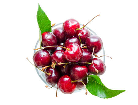 Ripe, red cherry in a glass bowl. Isolated cherries in the center of the photo on a light background. Natural vitamins in the summer.の写真素材