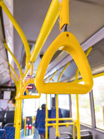 A large errand inside the bus. Half-empty public transport goes on its route. People go to work, on ground trangsport. There were more people on the buses.の写真素材