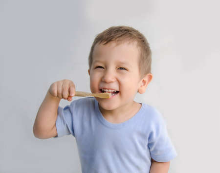 A child of European appearance, reads his teeth himself. The boy uses an eco-friendly toothbrush. Hygiene is good for the health of your teeth.の写真素材