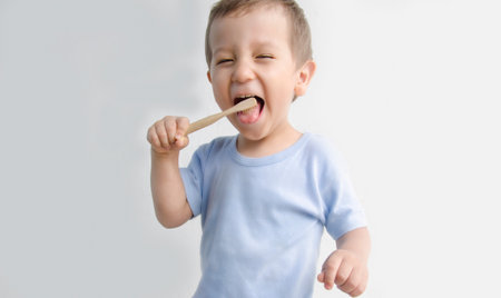 A child of European appearance, reads his teeth himself. The boy uses an eco-friendly toothbrush. Hygiene is good for the health of your teeth.の写真素材