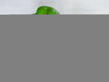 Fresh harvest of vegetables. Three bell peppers on a white wooden table. Sweet pepper removed from above. Vegetarian food for a healthy lifestyle.の写真素材