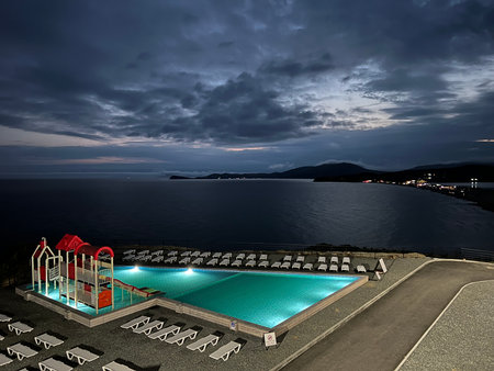 Swimming pool on the background of the sea and the night skyの写真素材