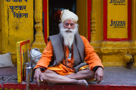 VARANASI,INDIA - March 22,2013 : Unidentified sadhu salutes people and sits on the streets of varanasiのeditorial素材