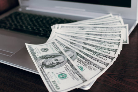Banknotes dollars over laptop keyboardの写真素材