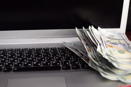Banknotes dollars over laptop keyboardの写真素材
