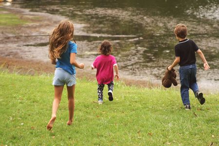 Children playing at lakeside, late summer/early autumn.の写真素材