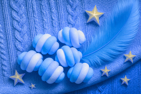 Blue and white candy on a blue knitted background with a starの素材