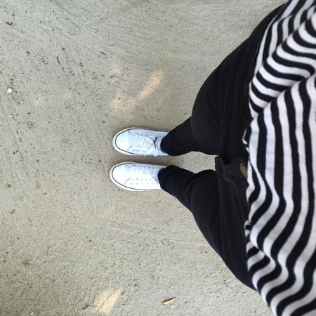 Gumshoes on urban grunge background of asphalt. Conceptual image of legs in boots on city. Feet shoes walking in outdoor. Youth Selphie Modern hipster.の写真素材