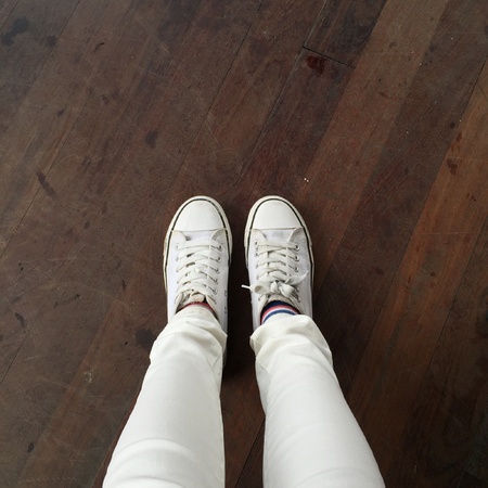 White Sneakers shoes walking on ground top view great for any use.の素材