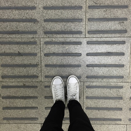 White Sneakers shoes walking on groundの素材