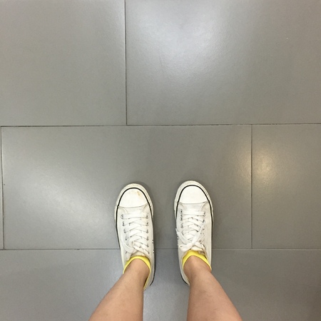 White Sneakers shoes walking on ground top view great for any use.の写真素材