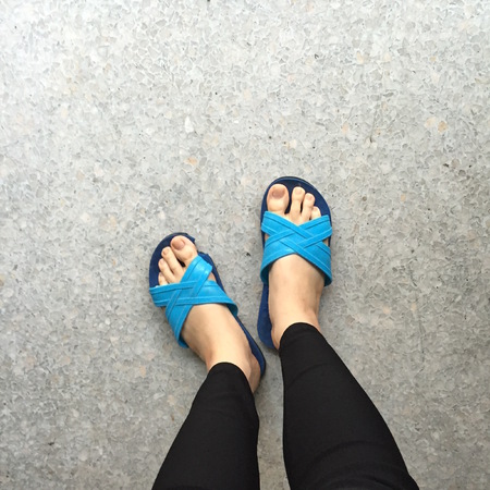 Woman Wearing Slippers Blue Standing on Ground or Floor Great For Any Use.の写真素材