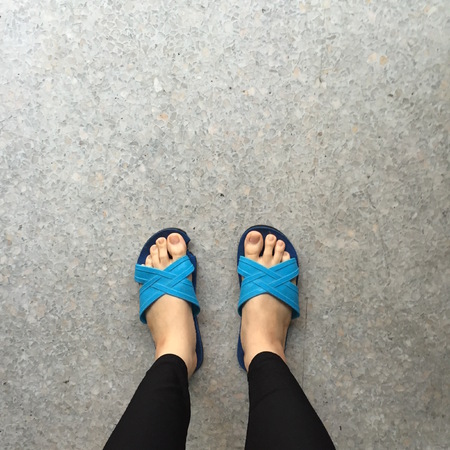 Woman Wearing Slippers Blue Standing on Ground or Floor Great For Any Use.の写真素材