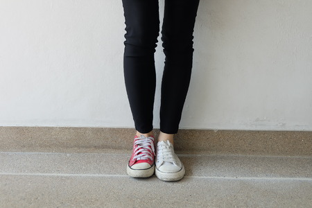 Funny Different Sneakers, Red and White Sneakers on Ground or Floor Background Great For Any Use.の写真素材