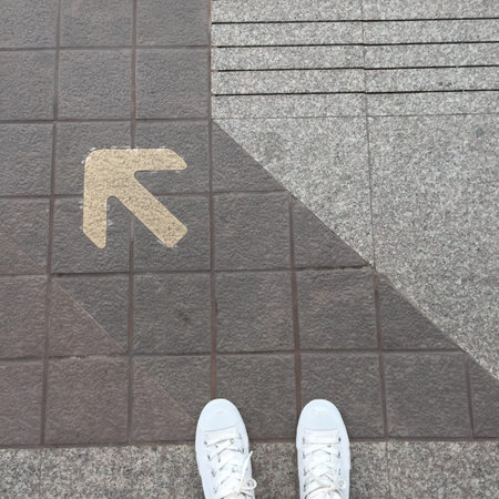 Female Feet in White Sneakers And Arrow Heading Forward Great for Any Use.の写真素材