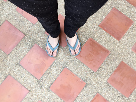Female Legs in Sandals on Tile Background Great For Any Use.