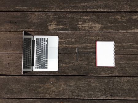 Laptop with Notebook and Pen on Wooden Table Great For Any Use.の写真素材