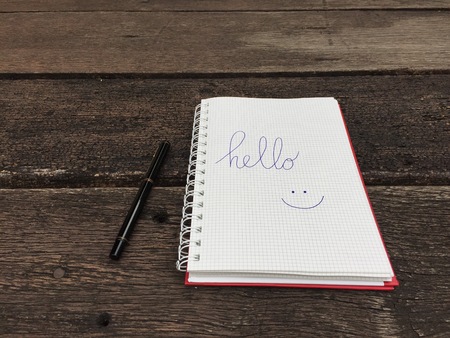Hello Notebook with Pen on Old Wooden Table Great for Any Use.の写真素材