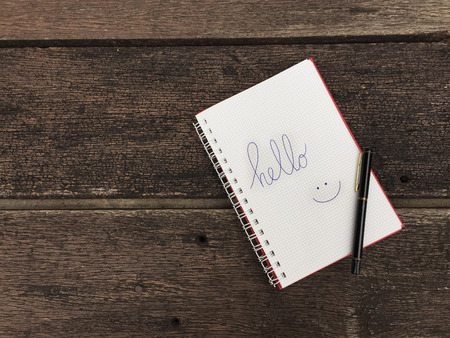 Hello Notebook with Pen on Old Wooden Table Great for Any Use.の写真素材