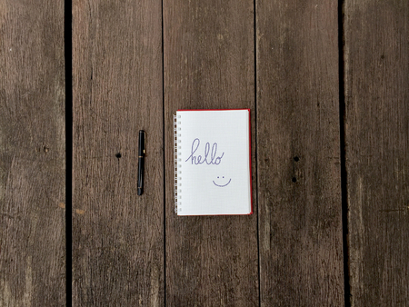 Hello Notebook with Pen on Old Wooden Table Great for Any Use.の写真素材