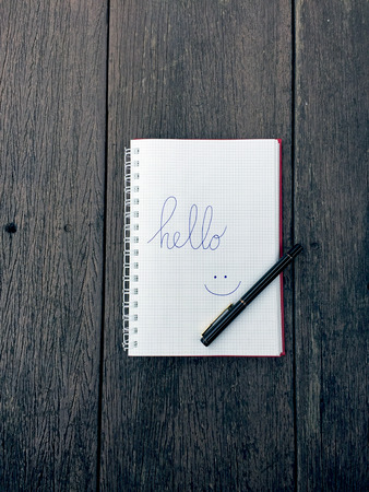 Hello Notebook with Pen on Old Wooden Table Great for Any Use.の写真素材