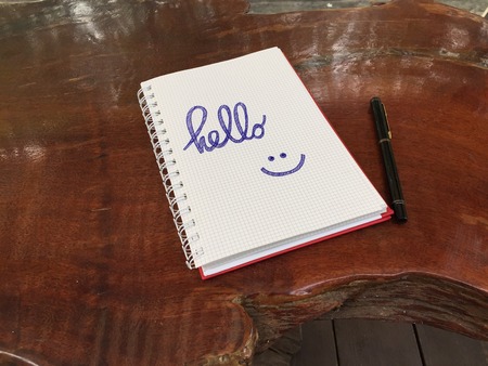 Hello Notebook with Pen on Old Wooden Table Great for Any Use.の写真素材