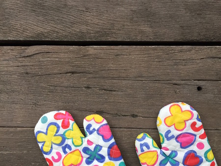Kitchen Protective Colourful Flower Gloves on Wooden Background Great For Any Use.の写真素材
