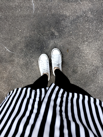 Young Fashion woman's Legs with Sneakers (White Shoes) on Floor Background Great For Any Use.の写真素材