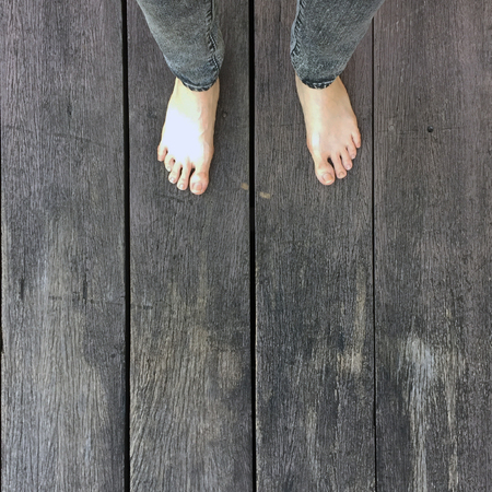 Woman's Jeans and Bare Feet on the Wooden Background Great For Any Use.の写真素材