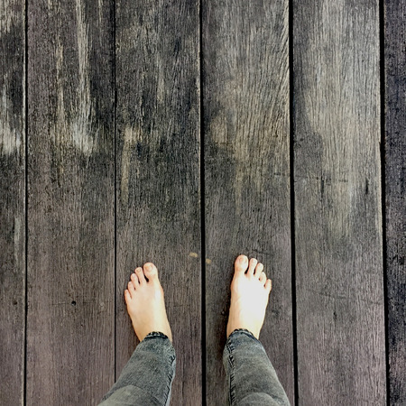 Woman's Jeans and Bare Feet on the Wooden Background Great For Any Use.の写真素材