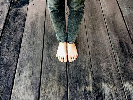Woman's Jeans and Bare Feet on the Wooden Background Great For Any Use.