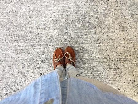 Woman's Legs in Blue Jeans and Brown Shoes on Concrete Floor Great For Any Use.