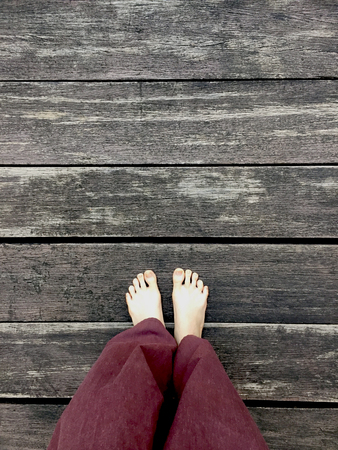 Woman's Lay pants and Bare Feet on the Wooden Background Great For Any Use.の写真素材