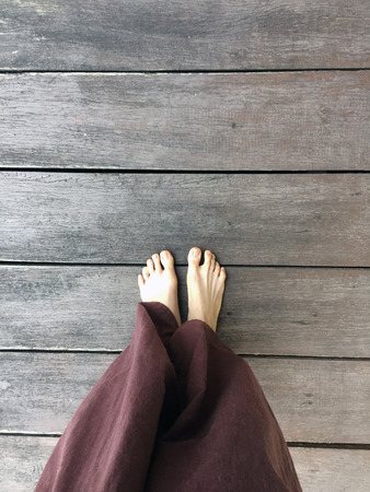 Woman's Lay pants and Bare Feet on the Wooden Background Great For Any Use.の写真素材