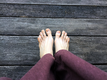 Woman's Lay pants and Bare Feet on the Wooden Background Great For Any Use.の写真素材