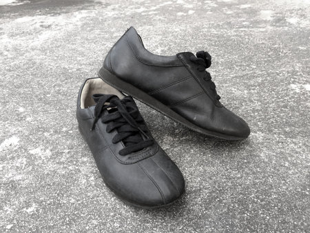 Old Black Shoes On The Concrete Floor Background Great For Any Use.の写真素材