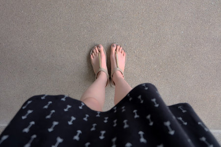 Close up of Dress and Slim Legs of Woman Wearing Gold Sandals on Ground Great For Any Use.