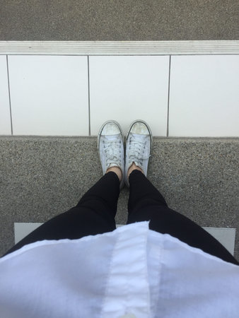 Closeup Photo of From Woman Wearing White Sneakers in The Street Great For Any Use.