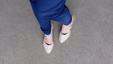 Woman Legs in High Heel Golden Sandals Stand on Ground, Outdoor Background Great For Any Use.