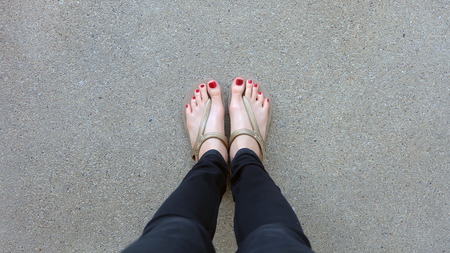 Close Up on Girl's Feet Wearing Golden Sandals on Ground Background Great For Any Use.の写真素材