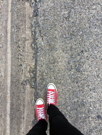 Closeup Photo of From Woman Wearing Red Sneakers On The Concrete Floor Background Great For Any Use.の写真素材